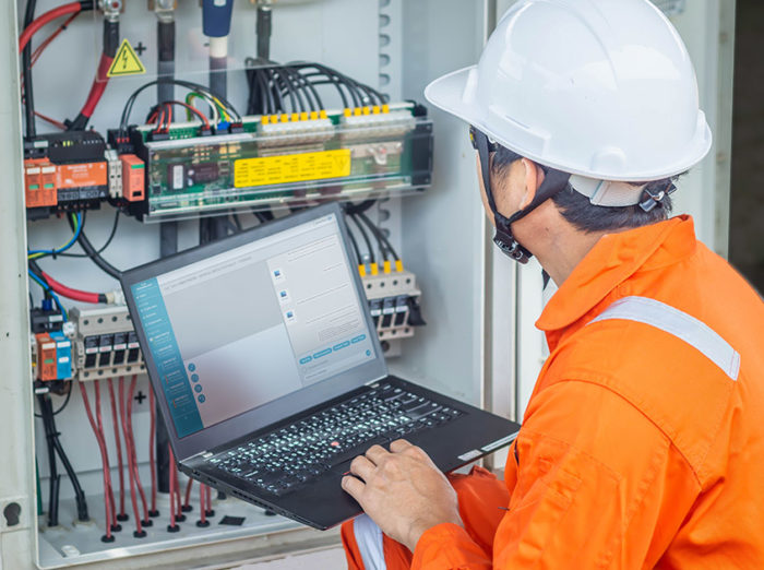 Engineers upload data of power energy to a laptop for checking the performance of the solar panel to confirming systems working normally. Concepts professional engineer for the Solar cell power plant.